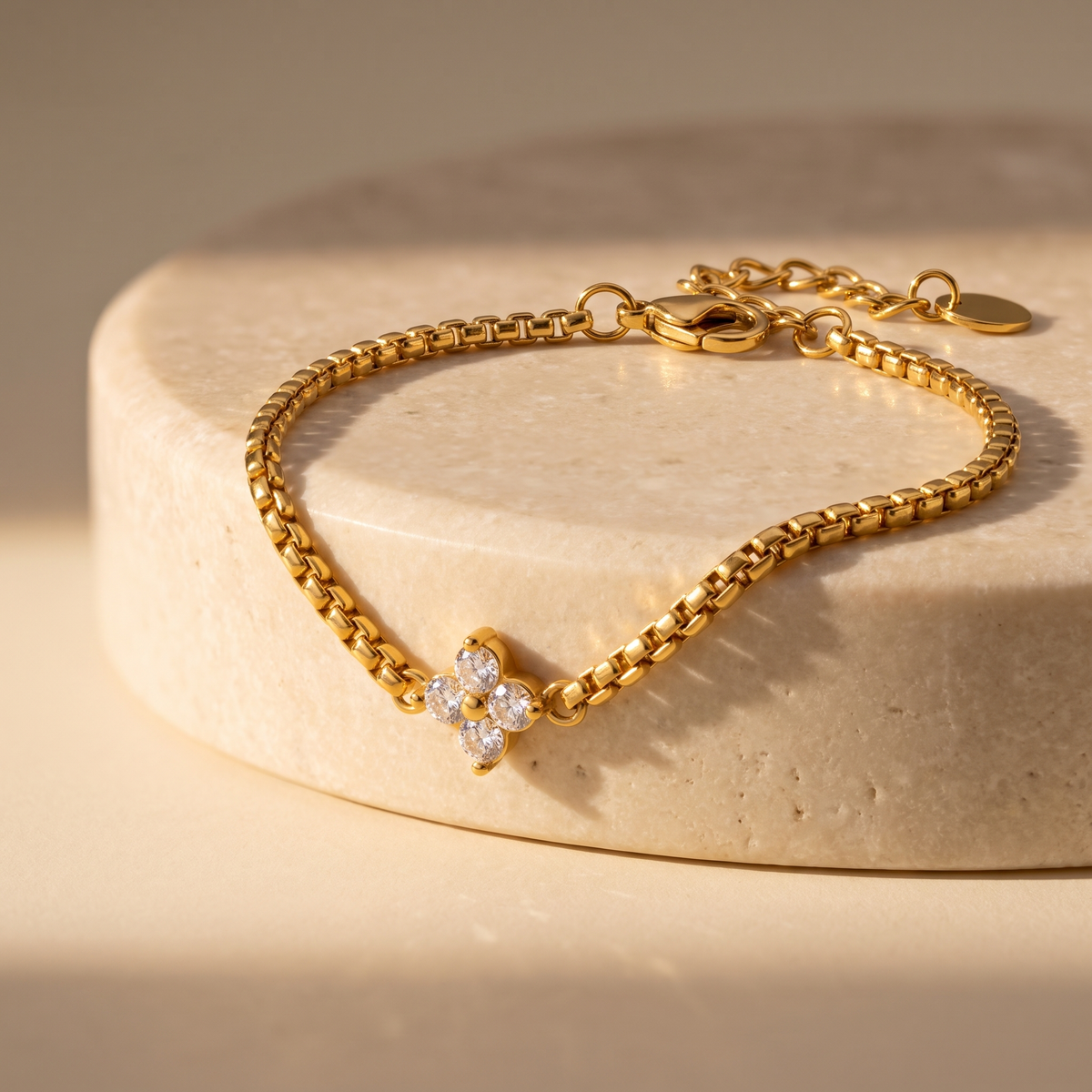 Isola Clover Box Chain Bracelet displayed on travertine