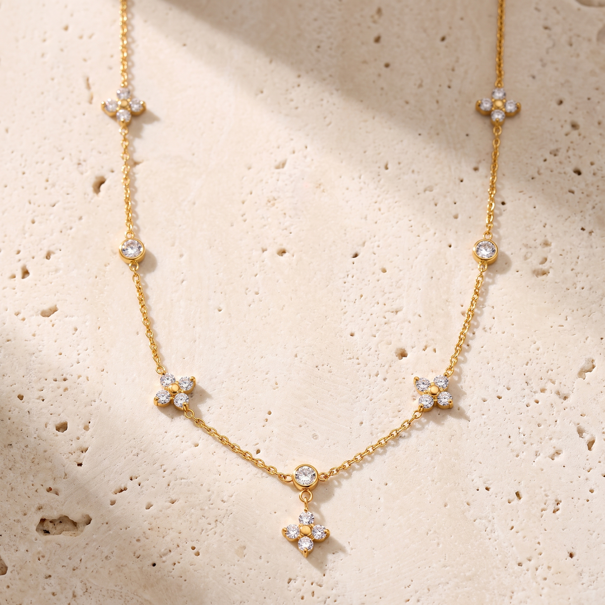 Mistral Clover Charm Necklace on travertine