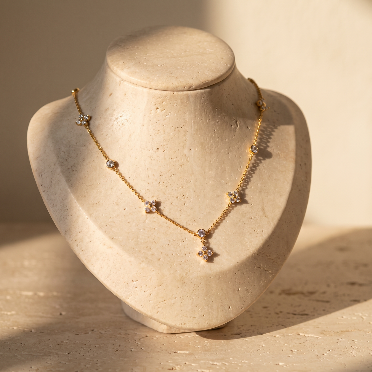 Mistral Clover Charm Necklace displayed on travertine