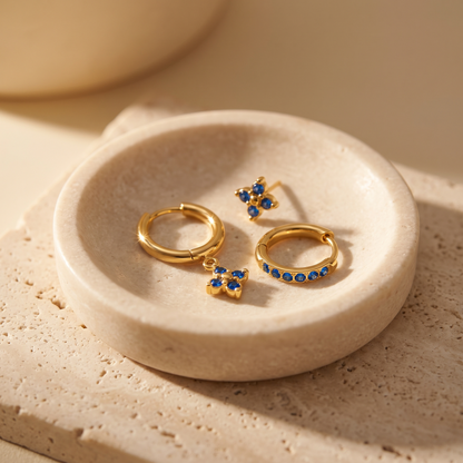 Myrtle Clover Stack Earrings in Blue displayed on travertine