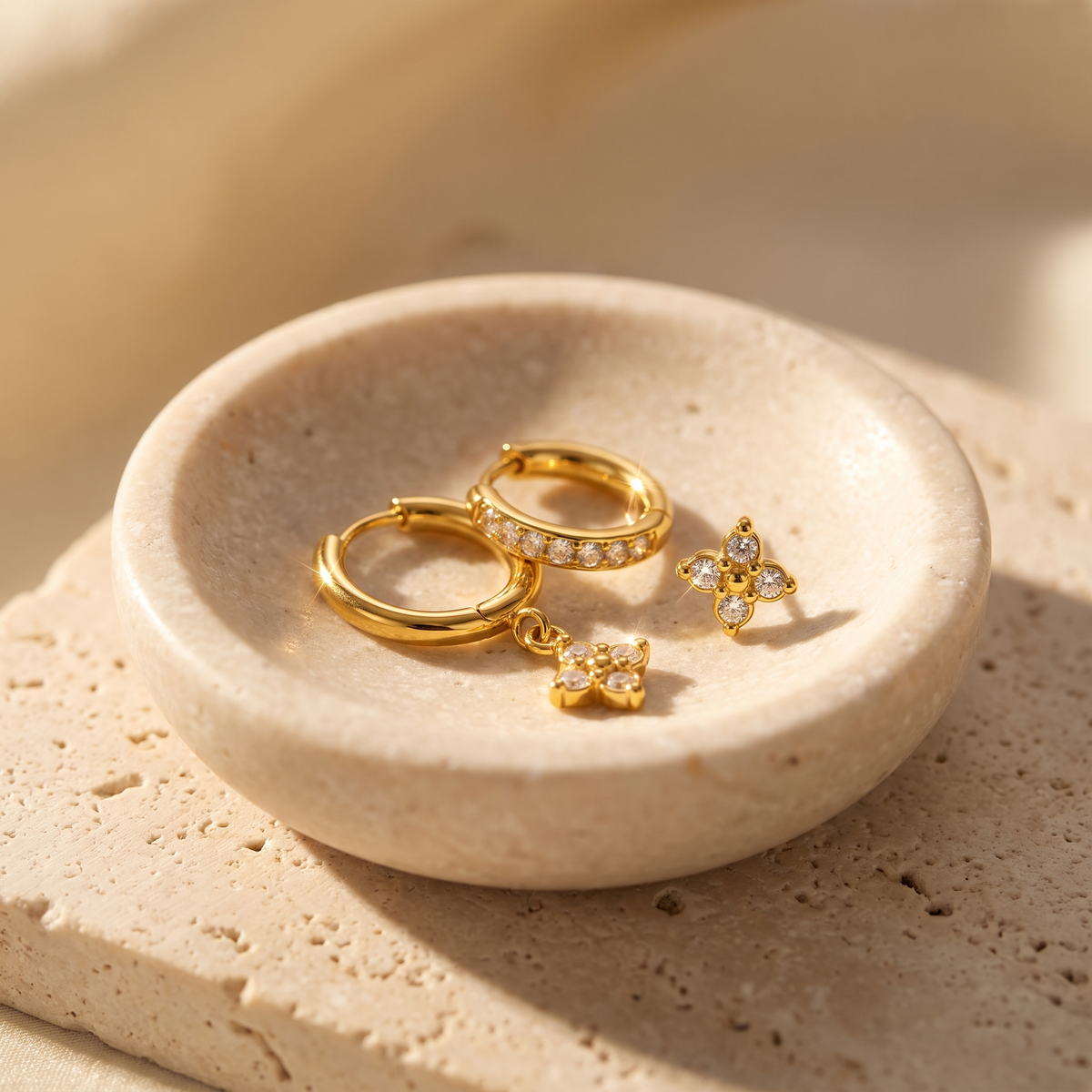 Myrtle Clover Stack Earrings in Clear displayed on travertine