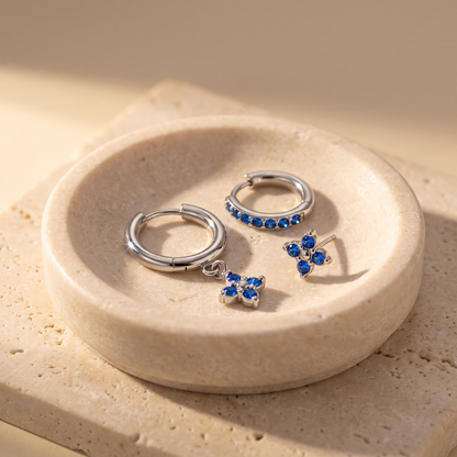 Myrtle Clover Stack Earrings in Silver displayed on travertine